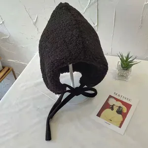 Detailed view of black sherpa earflap hat with warm fleece lining and ties for winter