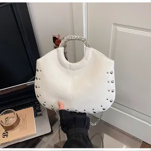 Macro view of off-white niche design handbag with silver rivets and metal handle detail
