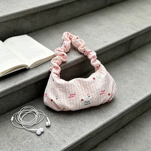 Detailed shot of a cute pink striped ruffled shoulder bag featuring strawberry patterns