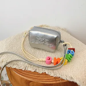 Detailed view of the silver mini crossbody square bag with vibrant colorful alphabet beads