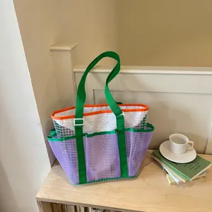 Colorful mesh tote bag featuring green straps and purple netting in a lifestyle setting.