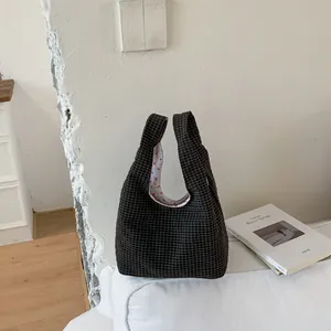 Schwarze Gittermuster-Stofftasche mit Herzfutter auf einem weißen minimalistischen Sofa