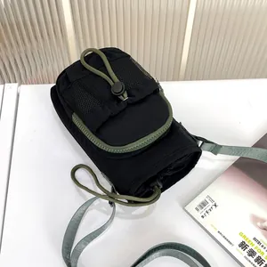 Primer plano detallado de un moderno bolso para móvil de nailon negro y verde con bolsillo de malla.