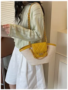 Vue latérale détaillée d'un sac à main en paille tressée jaune avec chaîne dorée