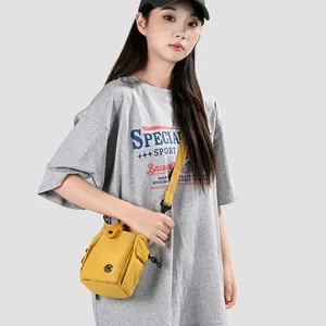 Vue détaillée du mini sac à bandoulière jaune pour téléphone porté par un mannequin