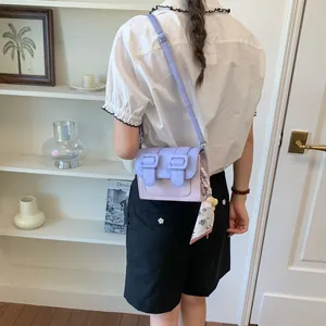 Stylish color-block crossbody bag with lavender tones and floral scarf accessory
