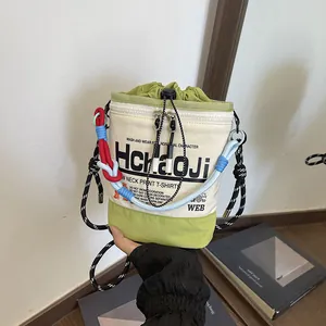 Detailansicht einer trendigen Canvas-Beuteltasche mit bunten Seilgriffen und Prints