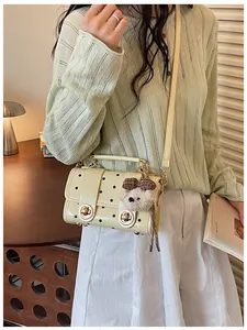Retro yellow polka dot crossbody bag for women with a cute bear charm accessory