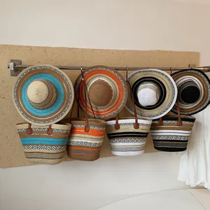 Sammlung großer Stroh-Strandtaschen und passender gestreifter Sonnenhüte zum Aufhängen.