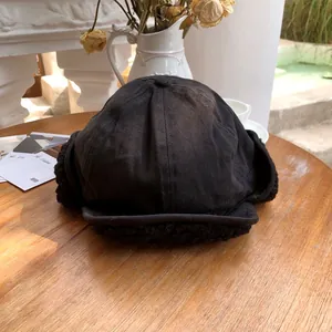 Detailed macro view of a black plush trapper hat with ear flaps for winter warmth