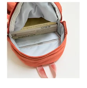 Detalle del interior de una elegante mochila naranja que muestra su gran capacidad.