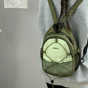 Vista de detalle de la mochila informal verde con bordado KAZEVO en una modelo