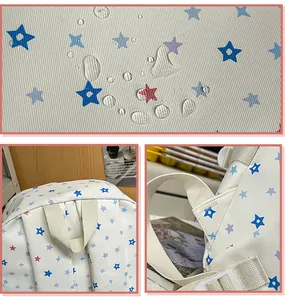 Macro view of waterproof fabric with blue star patterns on white school backpack