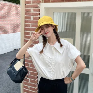 Fashionable yellow pleated bucket hat with wide brim worn by a model in outdoor setting