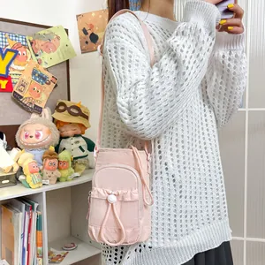 Elegante bolso bandolera de nailon rosa para móvil, mostrado en una modelo en casa