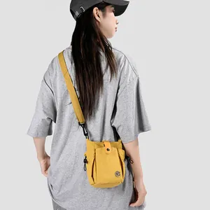 Mannequin avec mini sac à bandoulière jaune pour téléphone et T-shirt gris