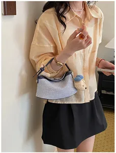 Detailed view of a stylish Korean light blue bucket bag with a cute plush bear charm