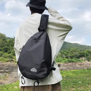 Vista posteriore di una borsa a tracolla da trekking nera a quadretti su un modello