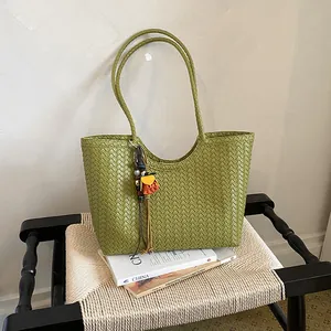 Elegante bolso de hombro tejido verde para verano en un ambiente minimalista