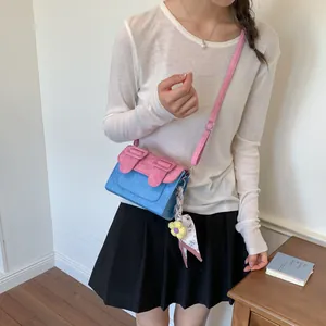 Model wearing a blue and pink contrast color crossbody bag with floral scarf accessory