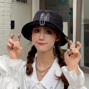 Trendy black women's bucket hat with cute white bunny ears embroidery for sun protection