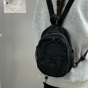 Primer plano de una mochila deportiva negra con cordón elástico y bolsillos laterales de malla
