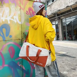 Modern orange and white crossbody travel bag shown on model in urban street setting