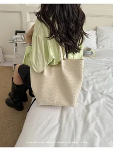 Close-up detail of a cream woven leather tote bag showing its elegant vintage texture.