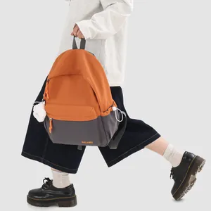 Detail shot of lightweight orange and grey two-tone school backpack with plush doll charm