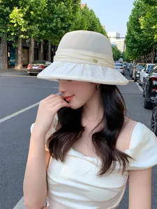 Elegant off-white breathable sun hat for women featured in a summer street outing