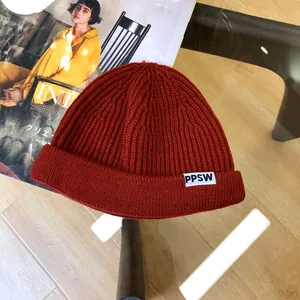 Detailed macro view of children reddish-brown knitted beanie with PPSW white label