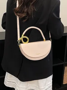 Elegante beige Satteltasche in Halbkreisform mit goldenem Metallgriff für Damen.