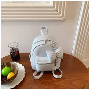 Stilvoller Mini-Rucksack in Hellblau mit dekorativer Schleife auf einem Holztisch
