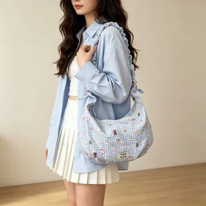 Close-up of a blue gingham dumpling bag featuring cute bear prints and ruffled strap
