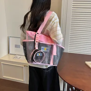 Detail view of a large capacity pink and black mesh tote bag for women commuting.