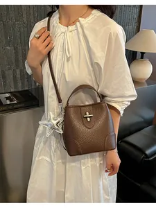Vue détaillée d'un sac seau en cuir marron texturé avec une breloque étoile argentée