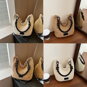 Hand-woven straw bucket bag with stylish black beaded handle in cream and tan colors
