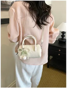 Elegant cream textured pillow bag with pearl tulip charm shown on model back