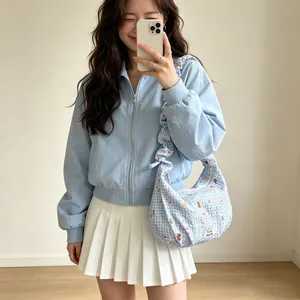 Detailed macro view of the blue checkered crossbody dumpling bag with a ruffled strap design