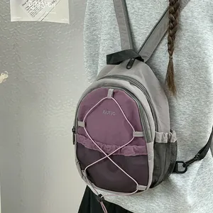 Vista detallada de una mochila deportiva morada y gris con diseño de cordón elástico en modelo.