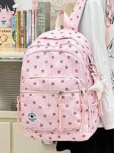 Pink backpack with star pattern and star charm shown in a cozy lifestyle room setting