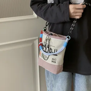 Detail einer lässigen Nischen-Beuteltasche mit trendigen Seilriemen in Pink und Off-White