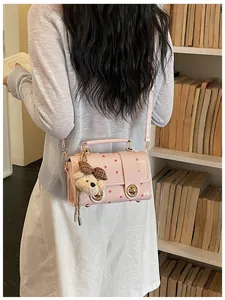 Elegant pink polka dot crossbody bag for women featuring a cute plush bear accessory