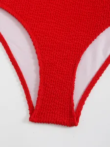 Dettaglio ravvicinato del tessuto seersucker rosso sullo slip bikini con fodera bianca