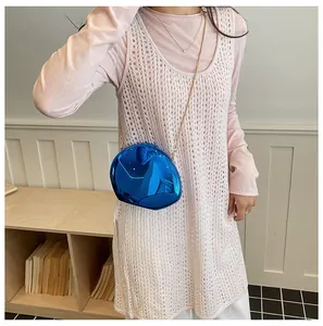 Modella che indossa un'elegante borsa da sera blu specchio a forma di conchiglia