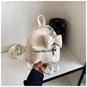 Eleganter cremefarbener Mini-Rucksack für Damen mit modischem Schleifen-Anhänger-Detail
