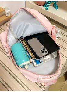 Interior view of pink large capacity school backpack with school supplies inside.