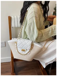Détail d'un sac cabas en paille tressée avec rabat matelassé blanc et bandoulière chaîne