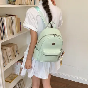 Zaino stile college verde menta intrecciato indossato da modella in biblioteca