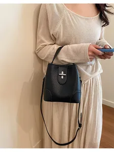 Photo de style de vie d'un sac seau vintage en cuir grainé noir avec fermoir en croix
